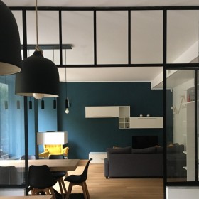 La couleur ottanio et les lumières personnalisées sont les protagonistes d'un appartement turinois